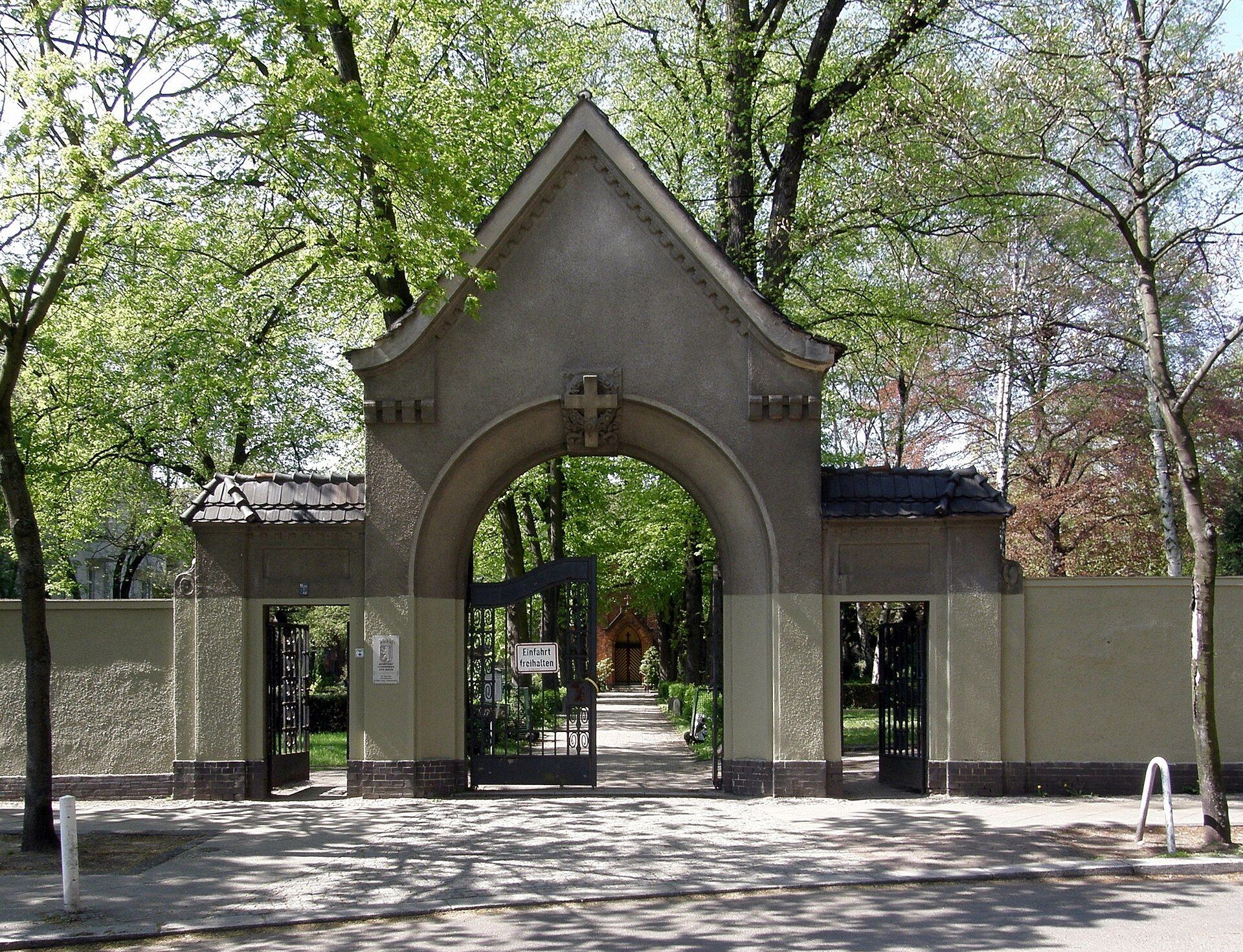 Historisches Hauptportal des Friedhofs Stubenrauchstraße mit Blick in die baumbestandene Hauptachse